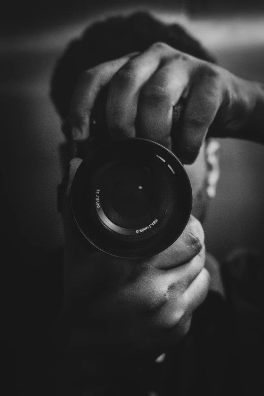 an eye looking through a lens while holding it up