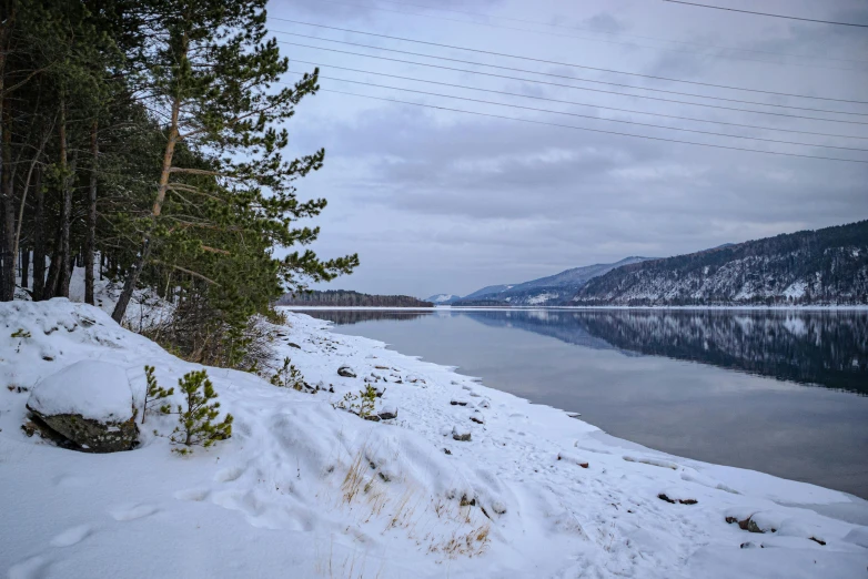 a snow covered shore near a lake on a winter day