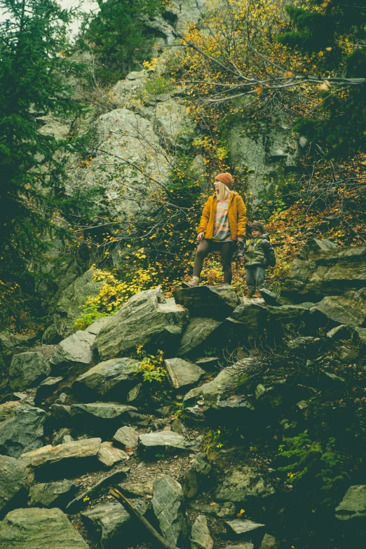 woman sitting on top of a pile of rocks on a mountain