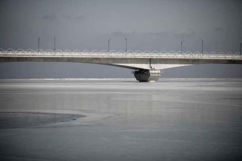 the ocean under a bridge with a truck parked under it