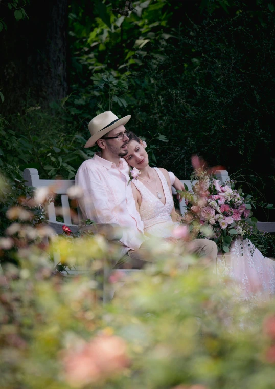 a couple sitting on a white bench in the garden