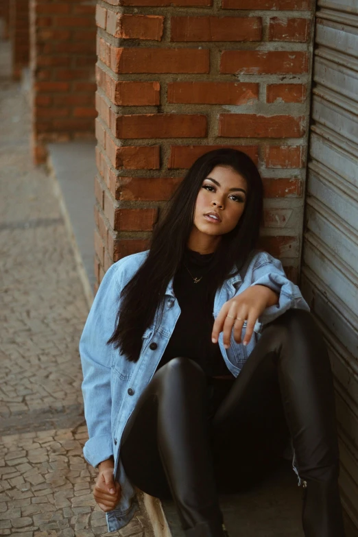 a woman is posing in leather pants outside