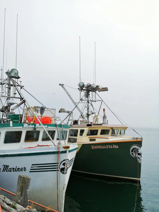 two small boats sitting next to each other in water