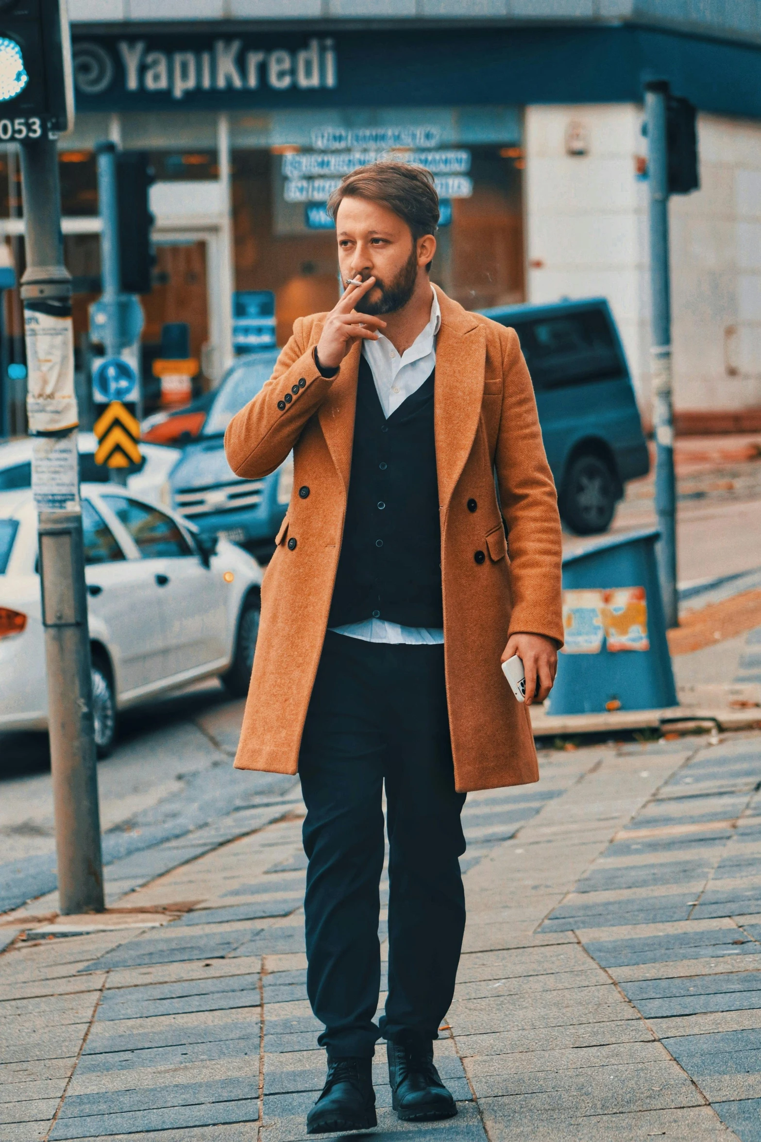 man walking down a city street in brown overcoat