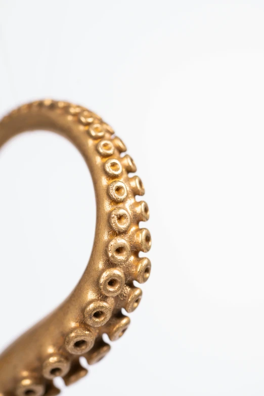 a golden octo ring on top of a white surface