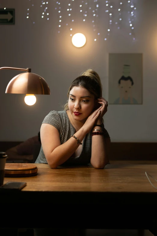 a woman sits at a table with her hands in her head