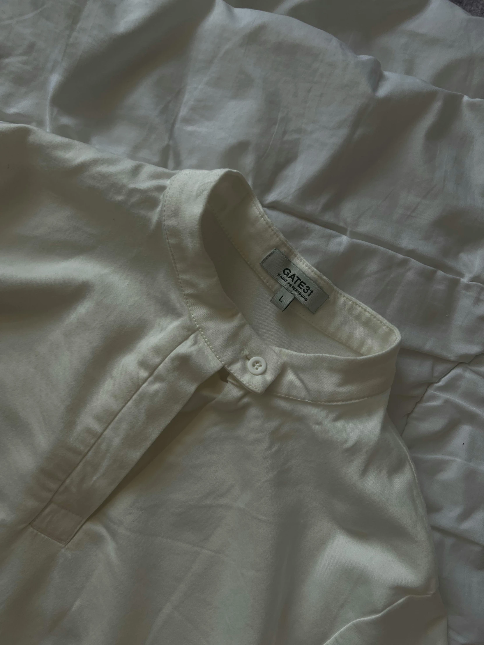 a white shirt is sitting on top of a bed