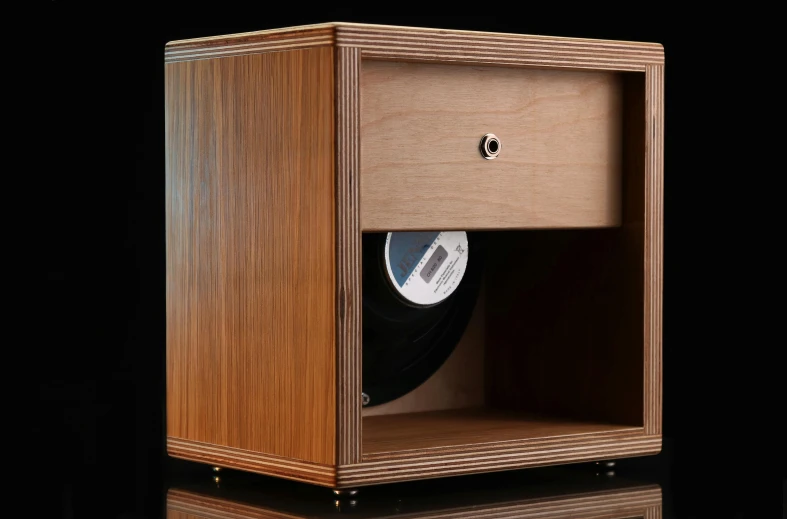 an old wooden record box has been opened and a black vinyl disc is seen