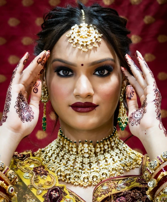 woman with makeup and jewelry standing in front of a red background