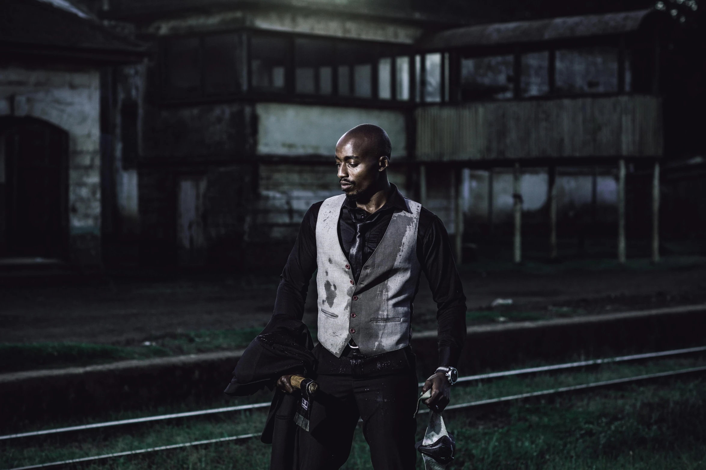 a man in the dark holding two pairs of skis