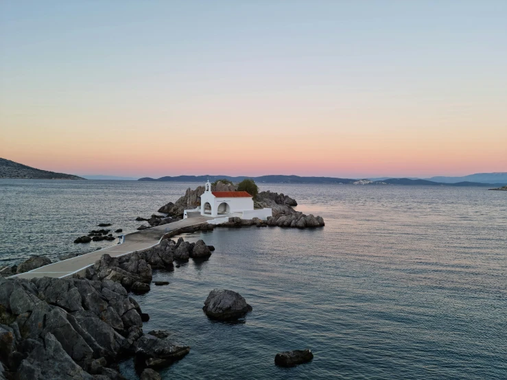 there is a small building that is on the side of the water