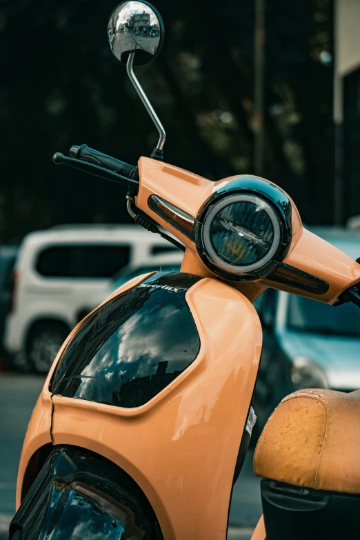 there is a orange scooter that is parked