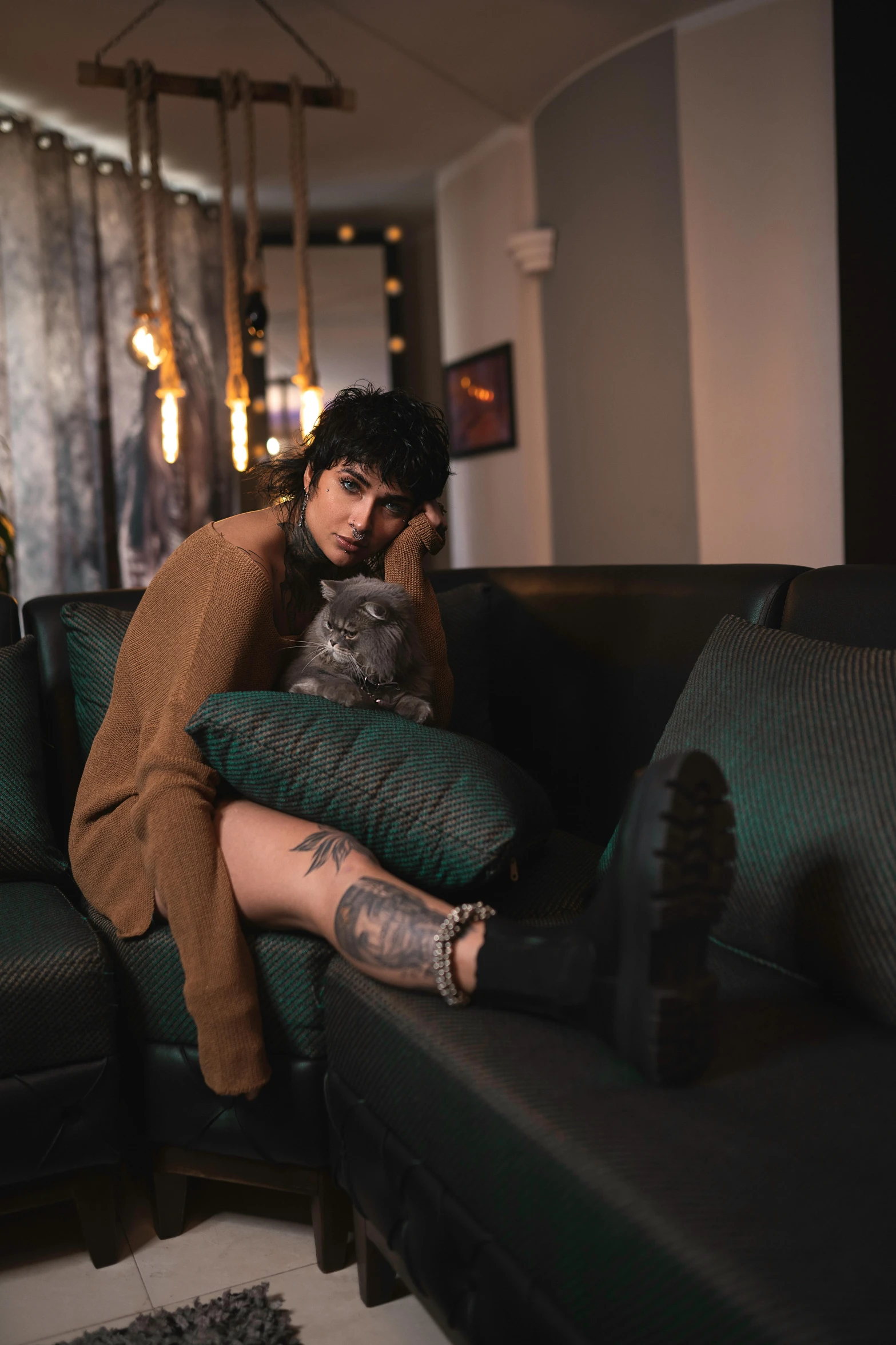 a woman sitting on top of a couch with a cat