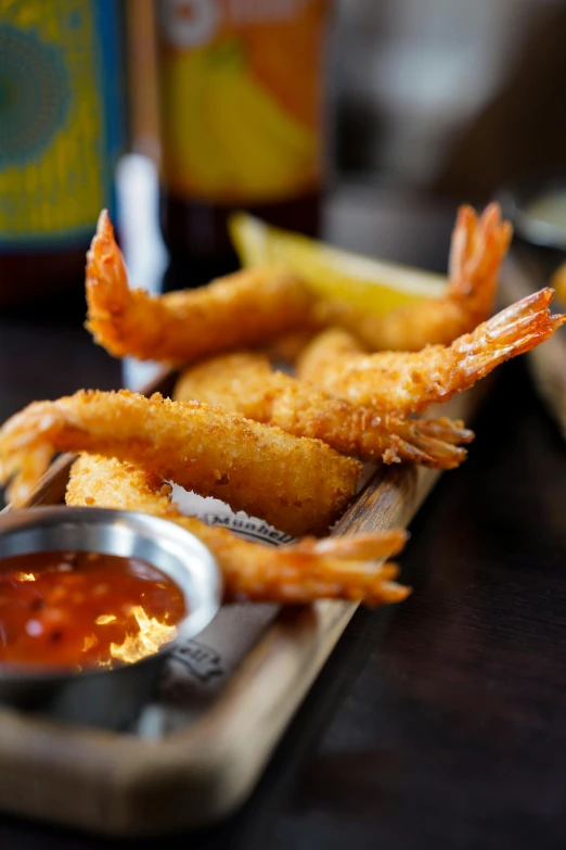 two shrimp sticks sitting on a tray with a sauce and dipping sauce