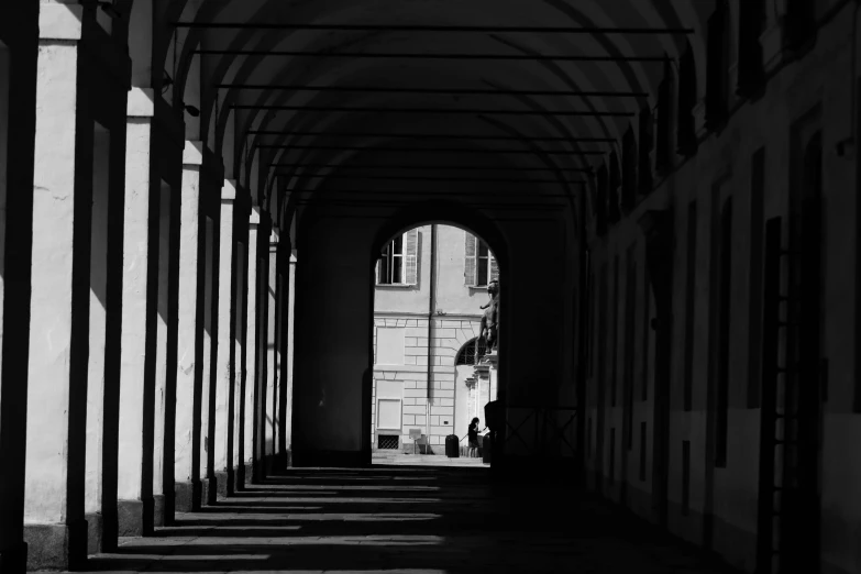 a person walking down an alley under a tunnel