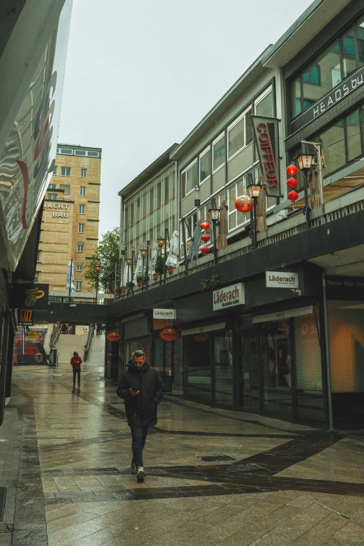 a person is walking down the street in front of buildings