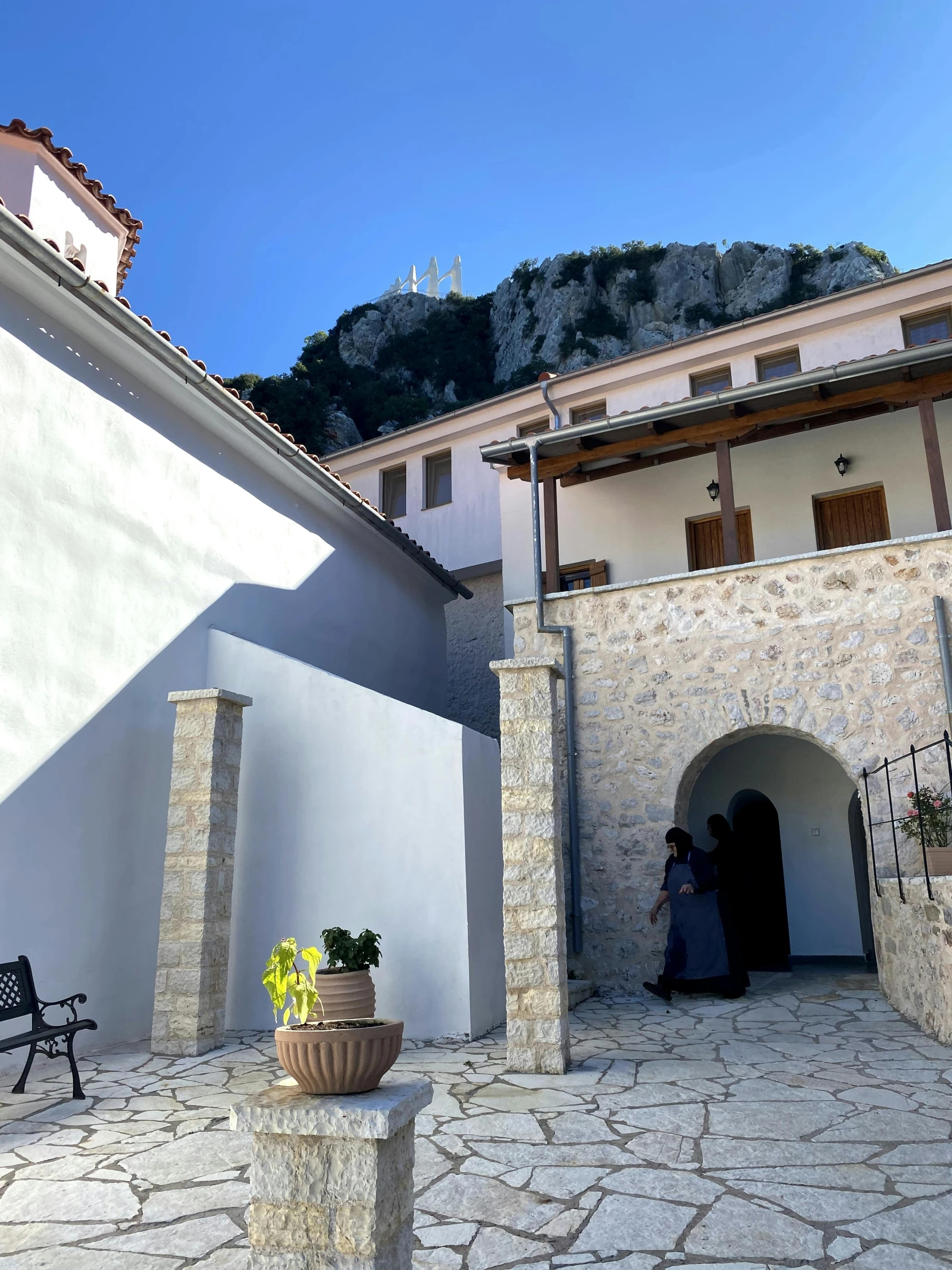 a couple standing inside an open courtyard between two houses