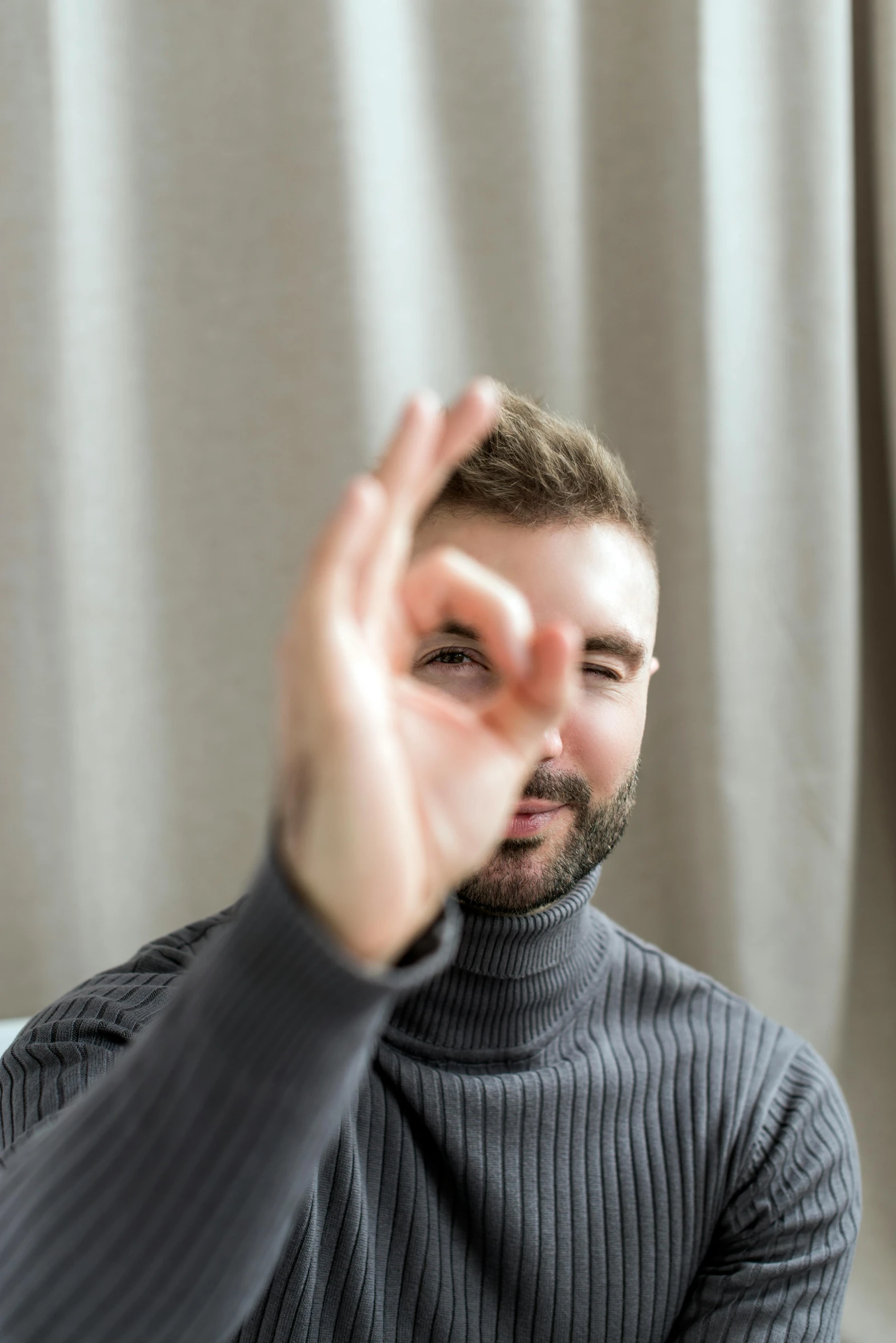 a man is sitting on a sofa and holding his hands up to the side