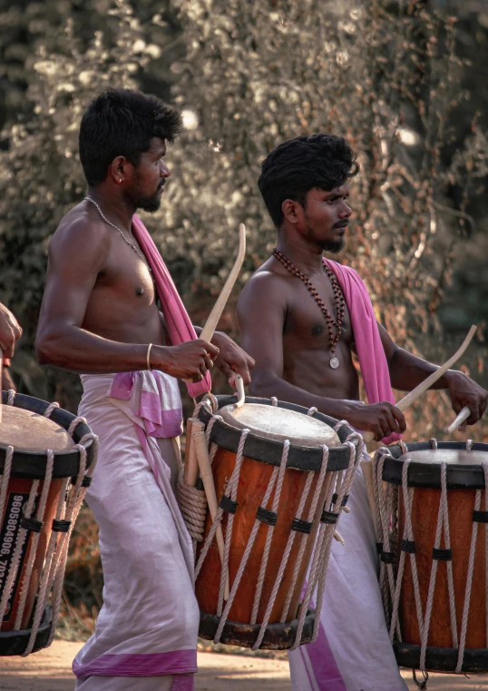 two men with s play drums outside