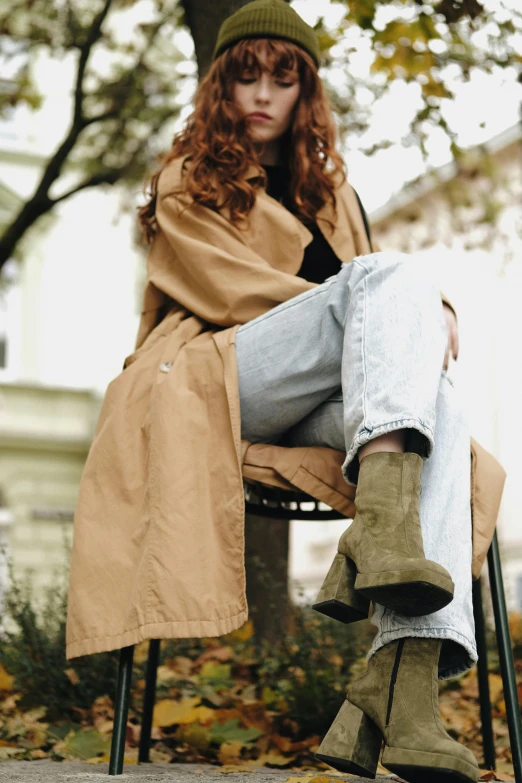 a woman is sitting on a chair in the leaves