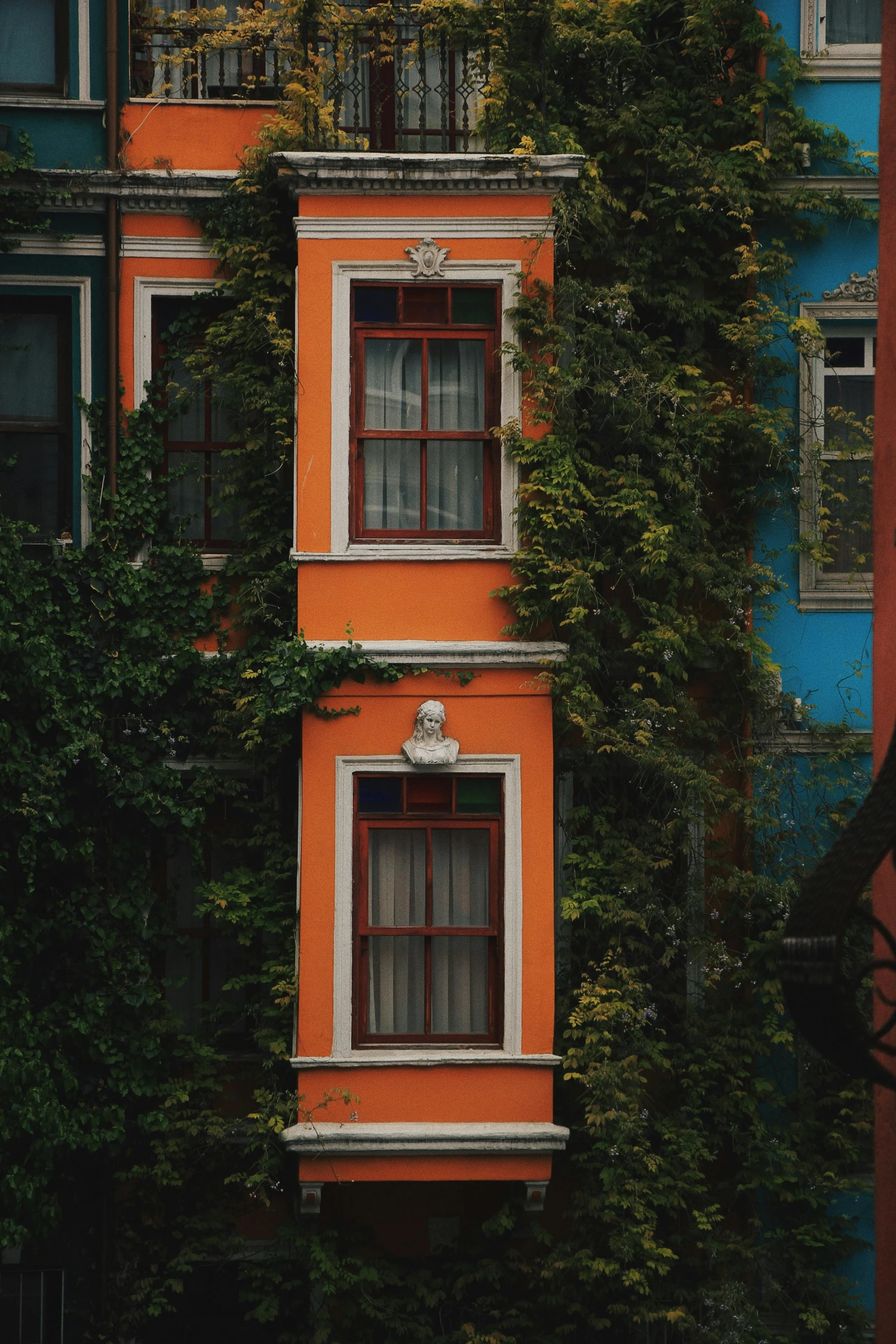 an orange building with ivy growing up the side