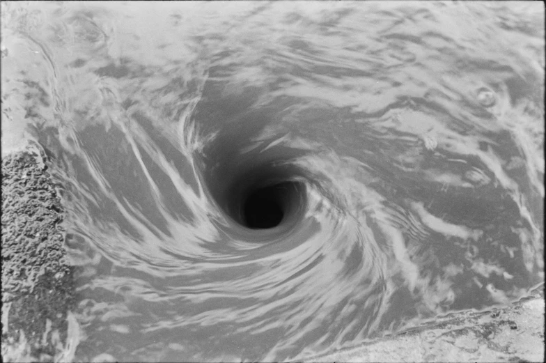 a black hole in the sand in the middle of the ocean