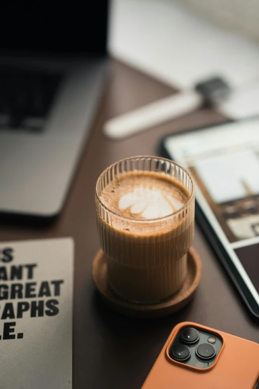 there is a smart phone near a cup on the table