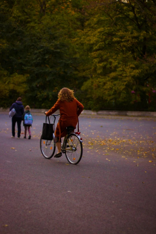 a woman is riding her bicycle with a little girl on the back