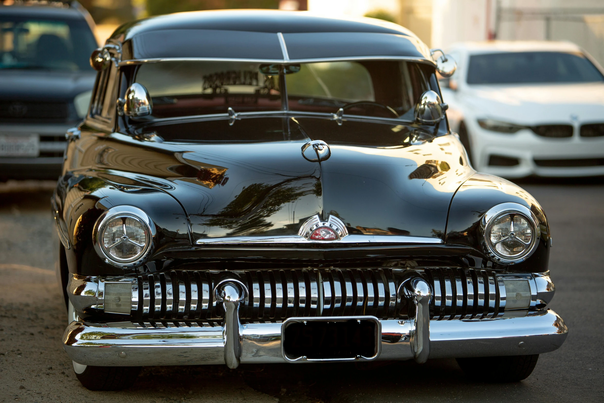 an old car on the road with other cars in the background