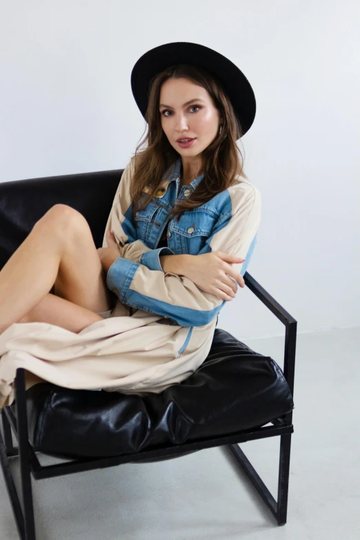 a woman sitting on a leather chair with her arms crossed