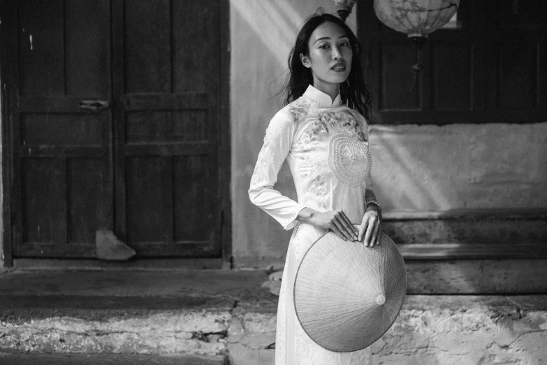 a woman posing for a black and white po holding a round object