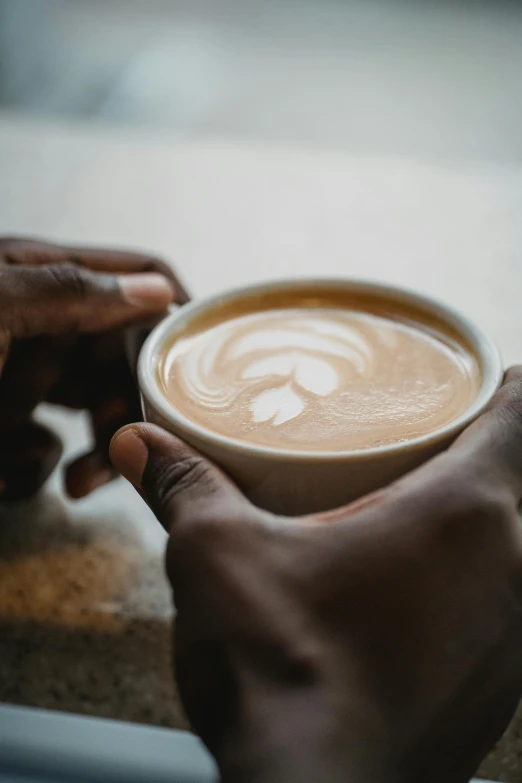 a close up of two hands holding a cup