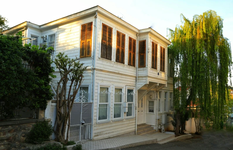 a big white house with several windows near a tree