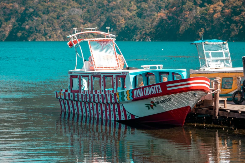 a colorful passenger boat is parked in the water