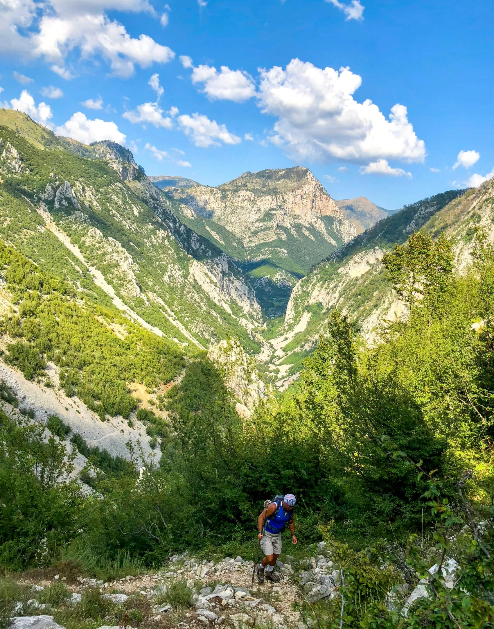 a man with a backpack trekking through a rocky mountain pass