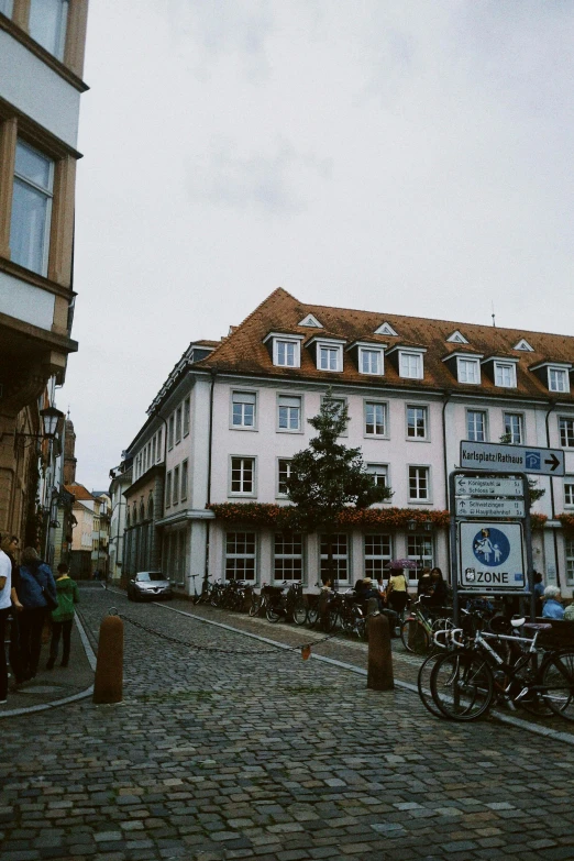 a brick sidewalk with people standing on it next to buildings