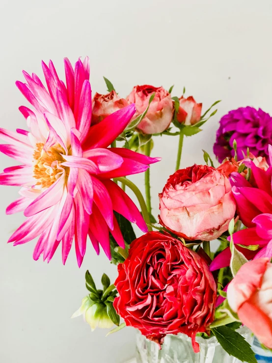 pink and red flowers in a vase on a table