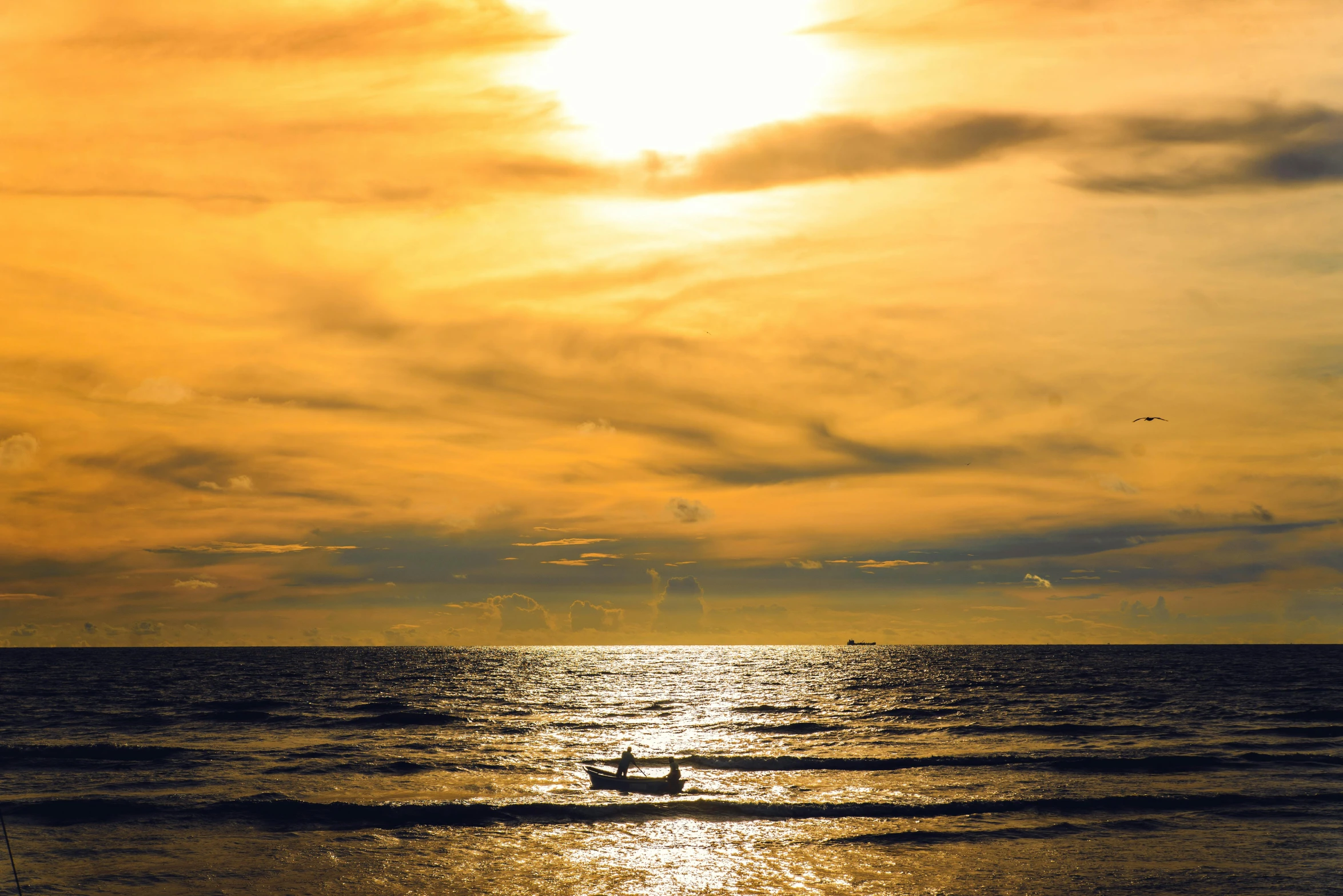 a boat on the water at sunset with a sky background