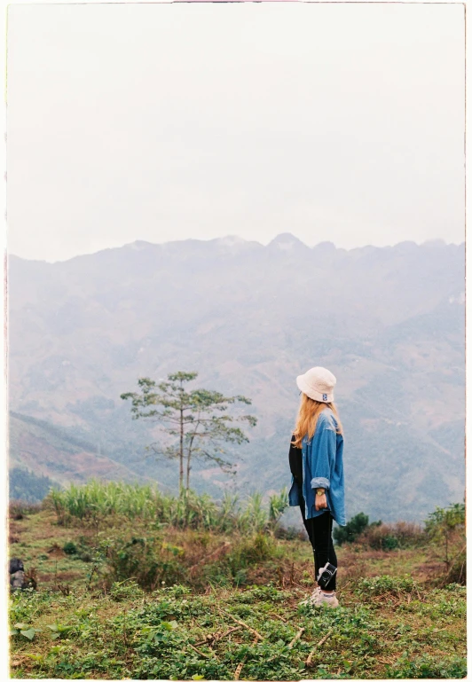 a woman that is standing on top of a hill