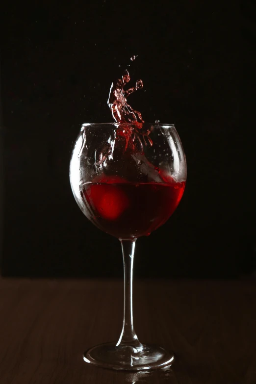 a wine glass is shown with wine being poured in it