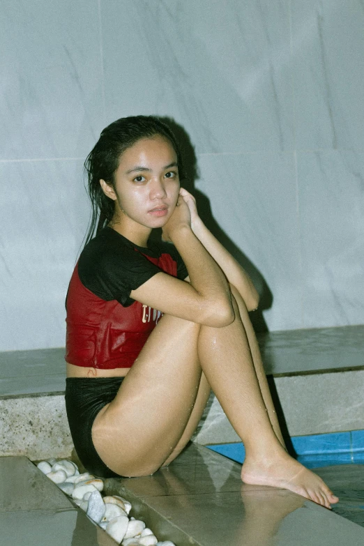 a girl sitting on a floor while posing for a picture