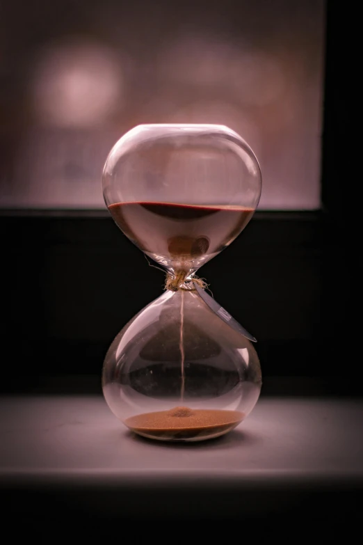 a hourglass with a liquid flowing from the top