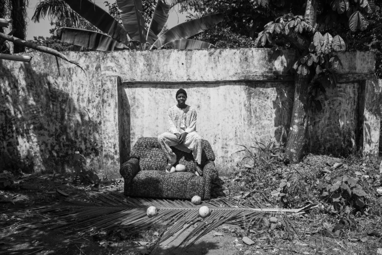 a man sits on a couch in an alley