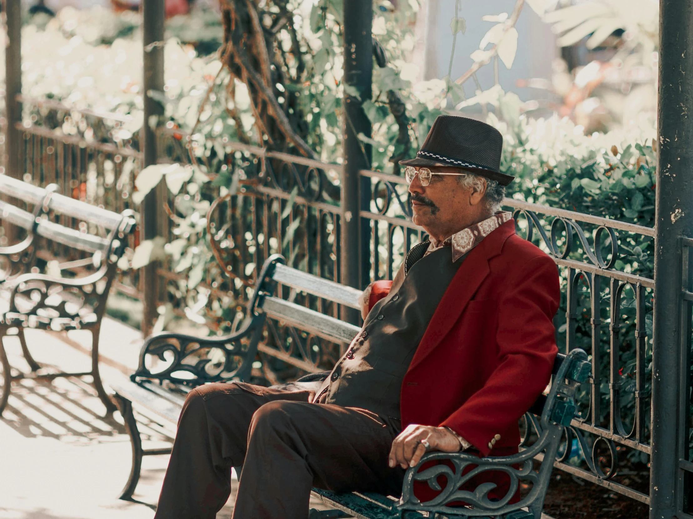 a man sitting on top of a bench in a park