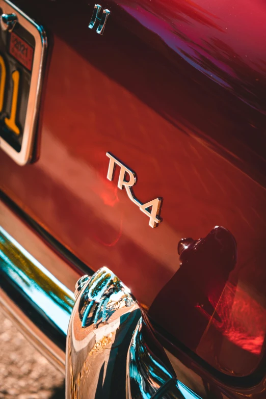 there is the front bumper of a red classic car