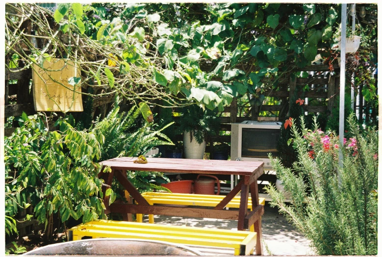 a yellow picnic table with a tv set in the background