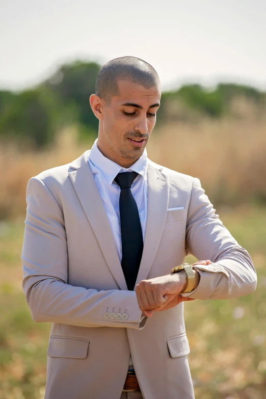 a man in a suit is checking his watch