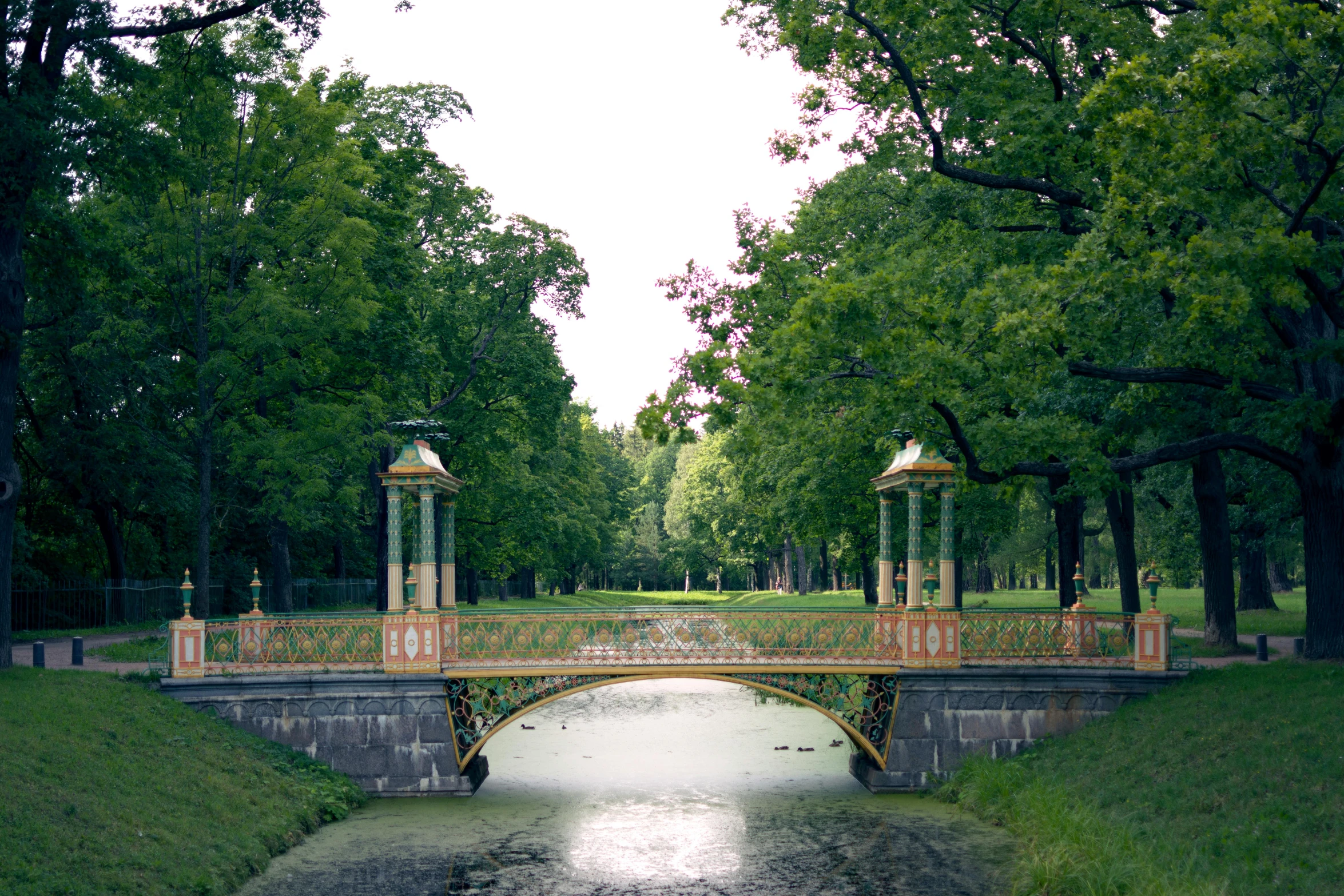 there is a bridge and a pond in the middle of the park