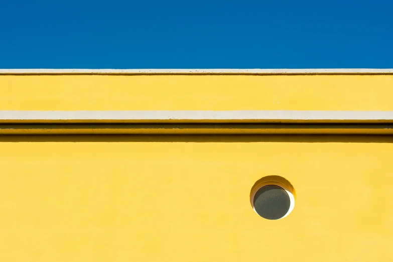 a yellow building with a black clock sitting in the window