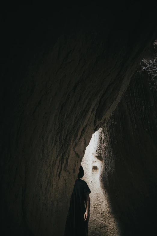 a man stands in the narrow tunnel at night